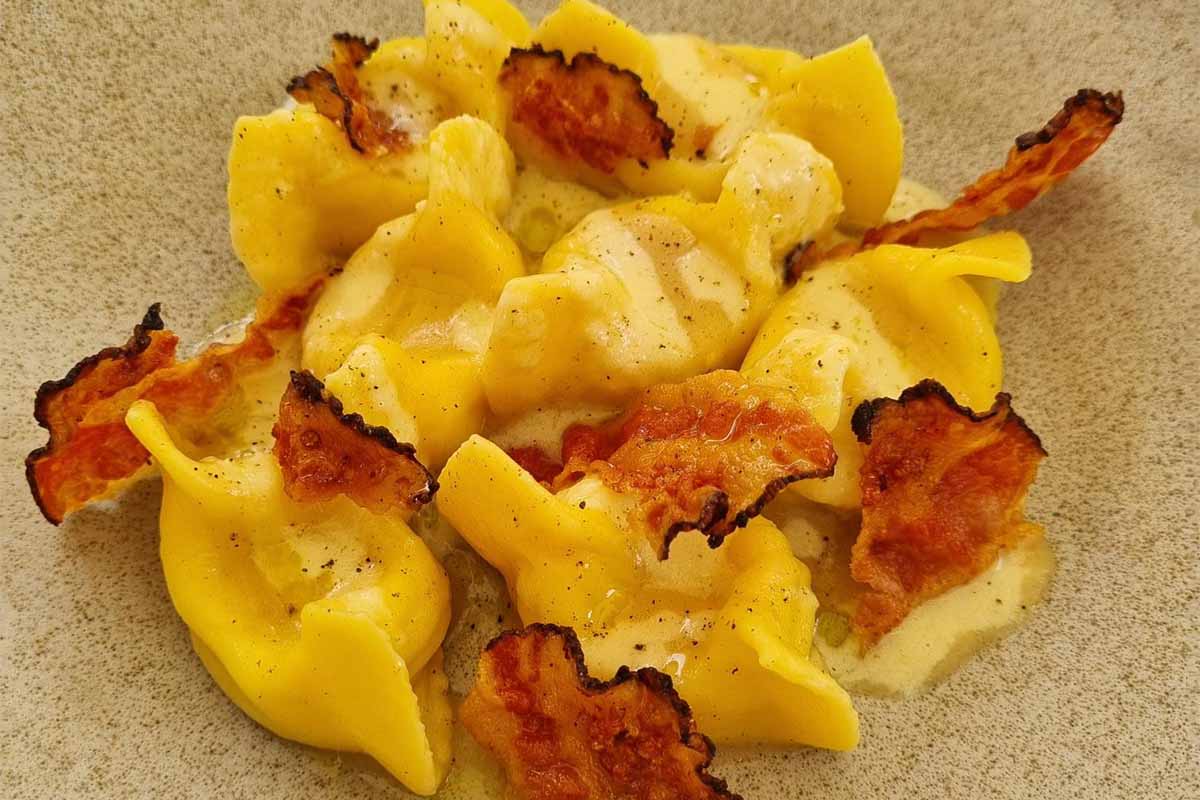 Tortelli di pecorino e patate, latticello alla cipolla, pepe nero e guanciale croccante copia.jpg